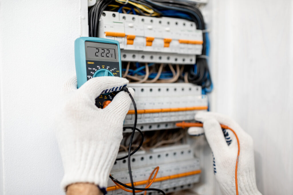 Mitarbeiter, der Elektro Kaufmann GmbH misst die Spannung in einem Schaltschrank.